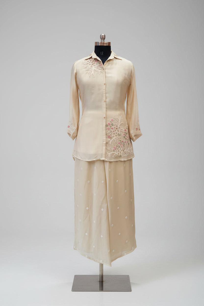 Mannequin wearing a beige outfit on a round platform with a plain background